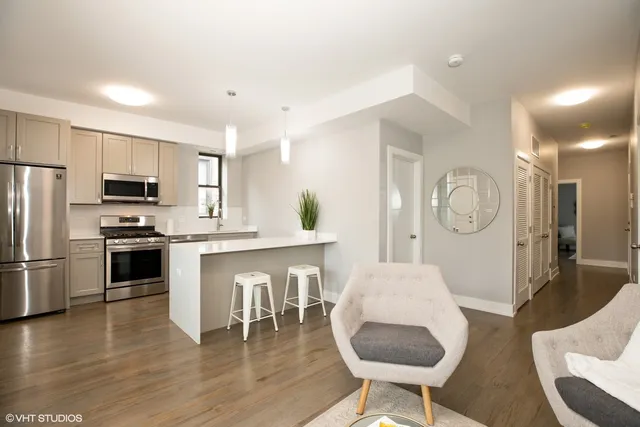 a kitchen with stainless steel appliances granite countertop a stove a refrigerator a oven a sink with a dining table and chairs