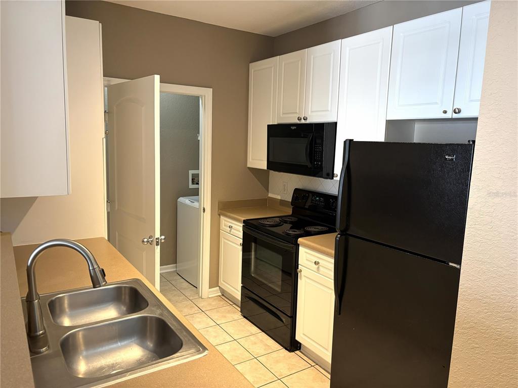 4221 West Spruce Street, Unit 1418 Tampa, FL 33607 - Photo 6 of 22 a kitchen with a refrigerator sink and cabinets
