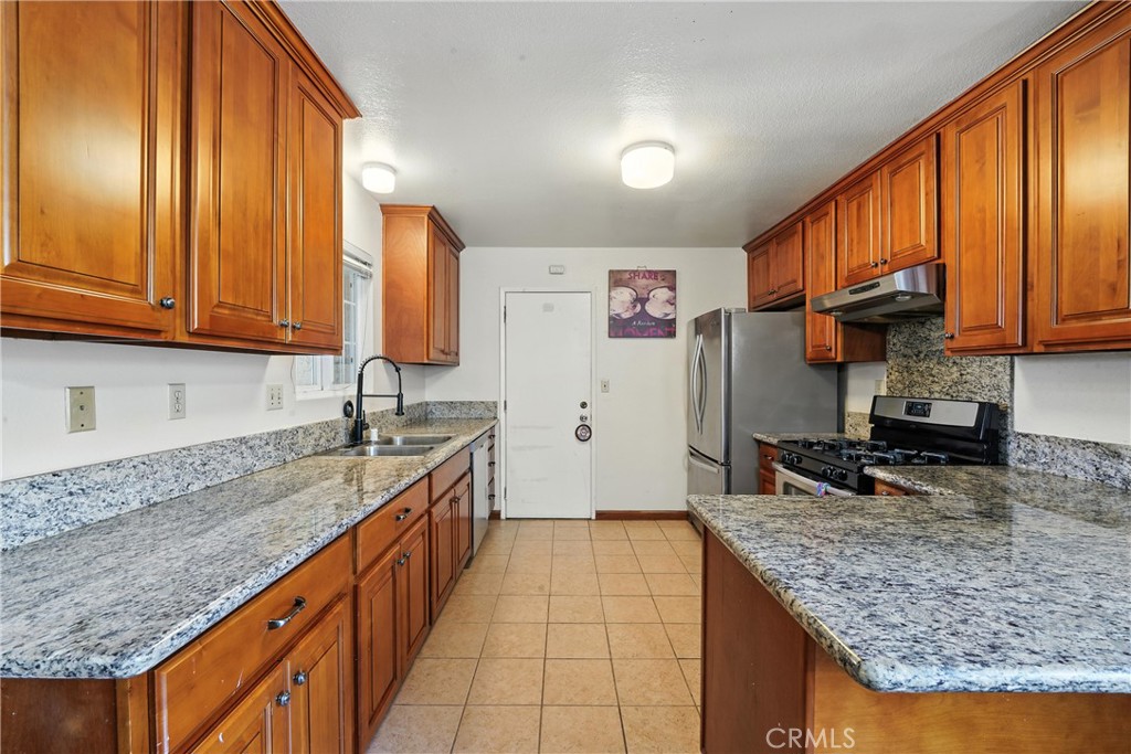 11813 Colima Road Whittier, CA 90604 - Photo 6 of 19 a kitchen with stainless steel appliances granite countertop a sink stove and refrigerator