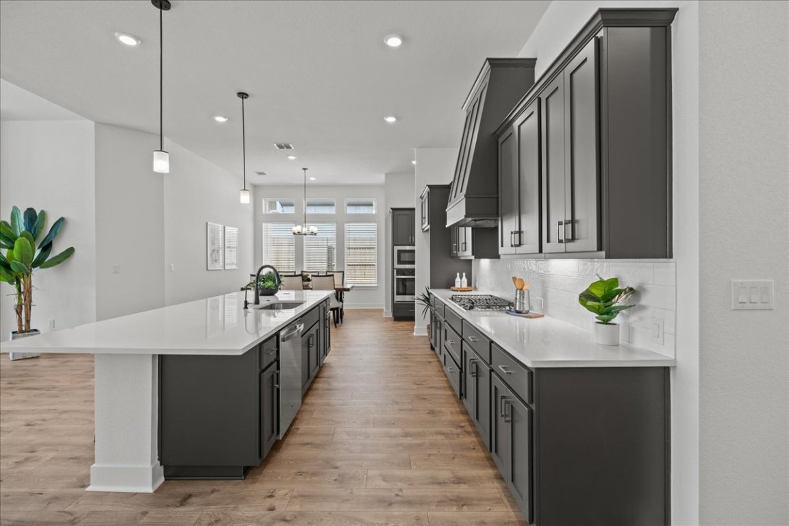 231 Begonia Street Buda, TX 78610 - Photo 19 of 27 a large kitchen with stainless steel appliances a sink and a large window