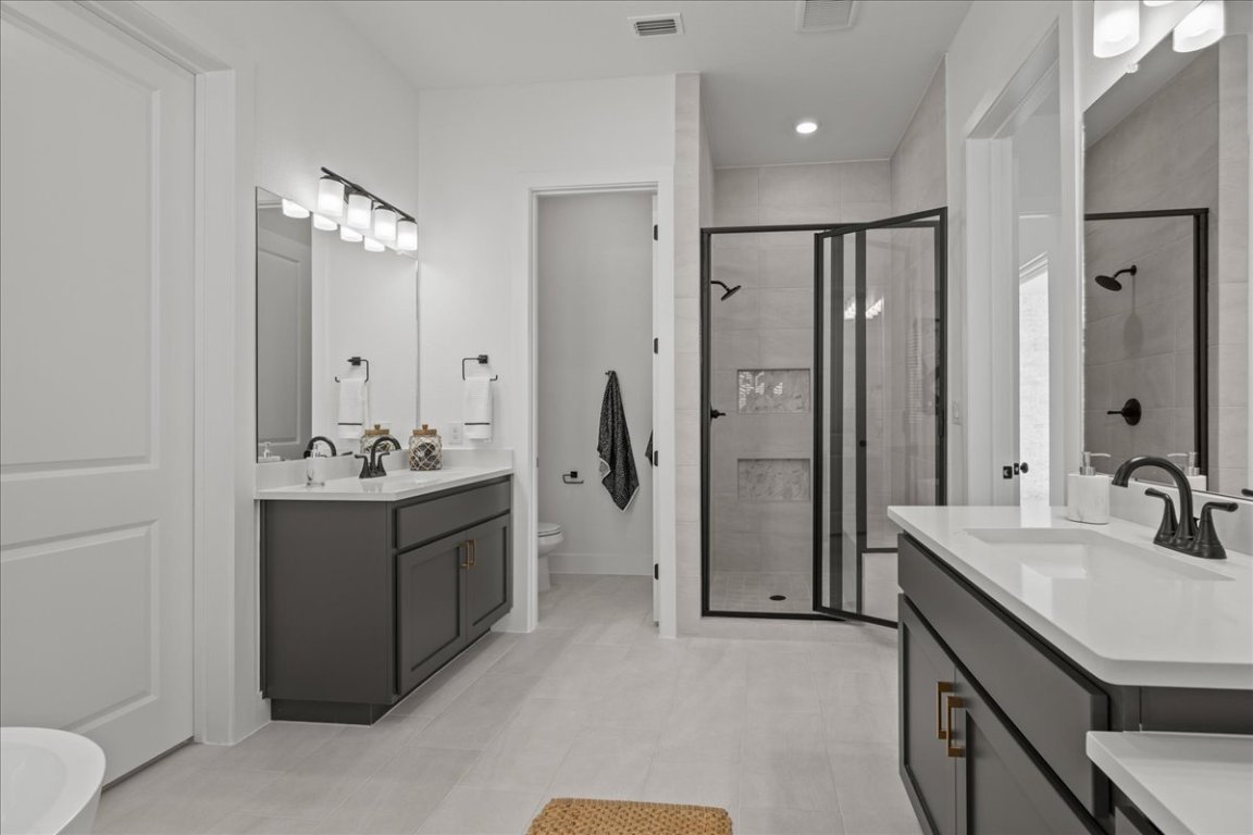 231 Begonia Street Buda, TX 78610 - Photo 24 of 27 a bathroom with a double vanity sink mirror and shower