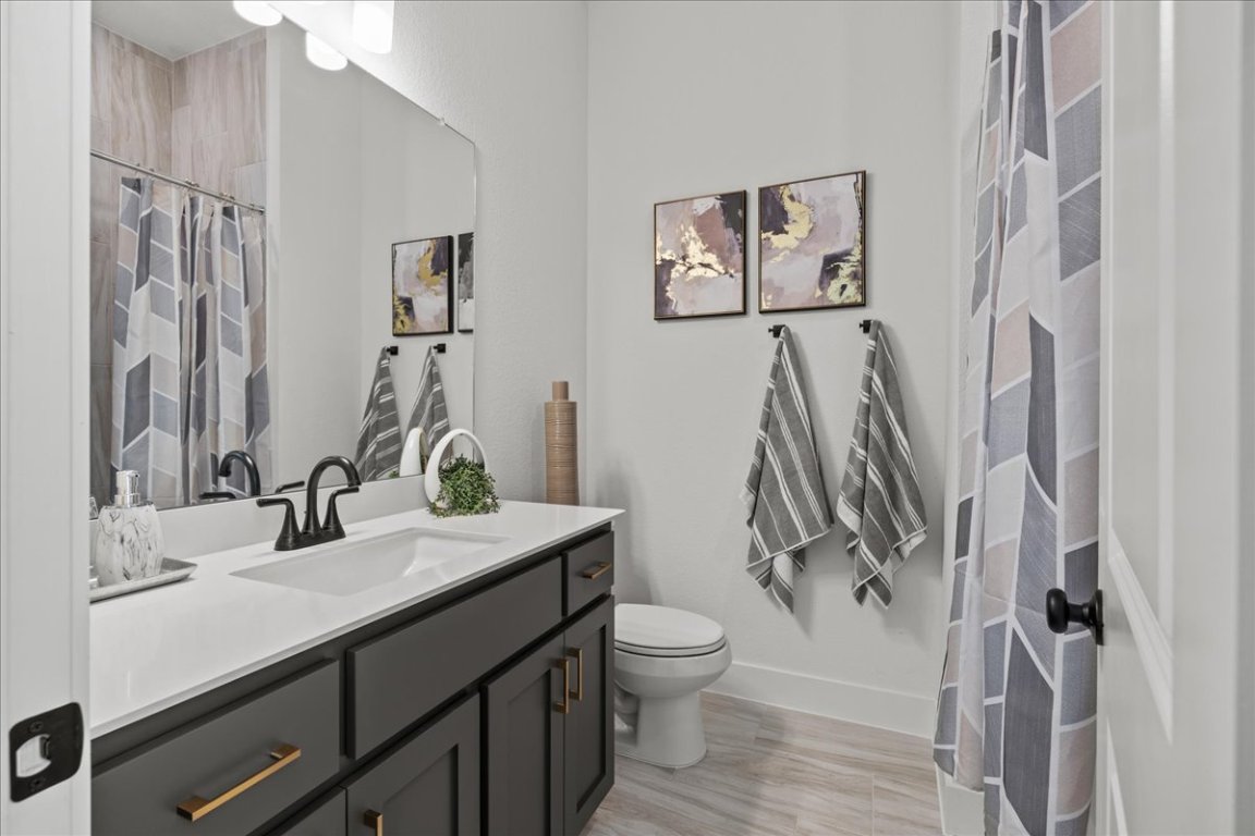 231 Begonia Street Buda, TX 78610 - Photo 26 of 27 a bathroom with a sink vanity mirror and toilet