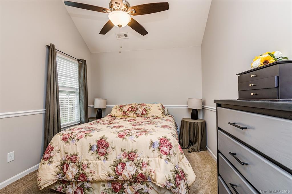 2736 Rustic Ridge Court Rock Hill, SC 29730 - Photo 18 of 23 a bedroom with a bed and a chandelier