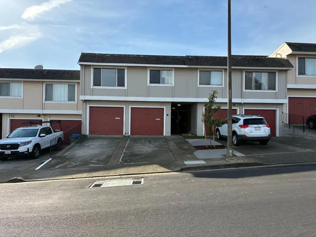 a front view of a house with parking space and a car parked