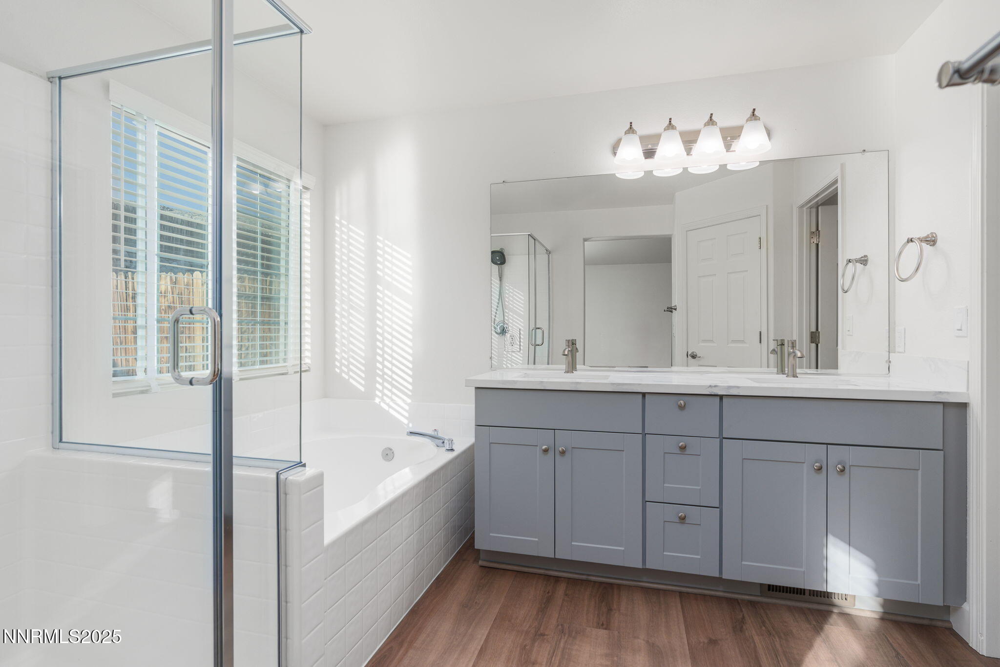 2905 Scepter Court Reno, NV 89503 - Photo 19 of 30 a bathroom with a double vanity sink a mirror a bathtub and next to a window