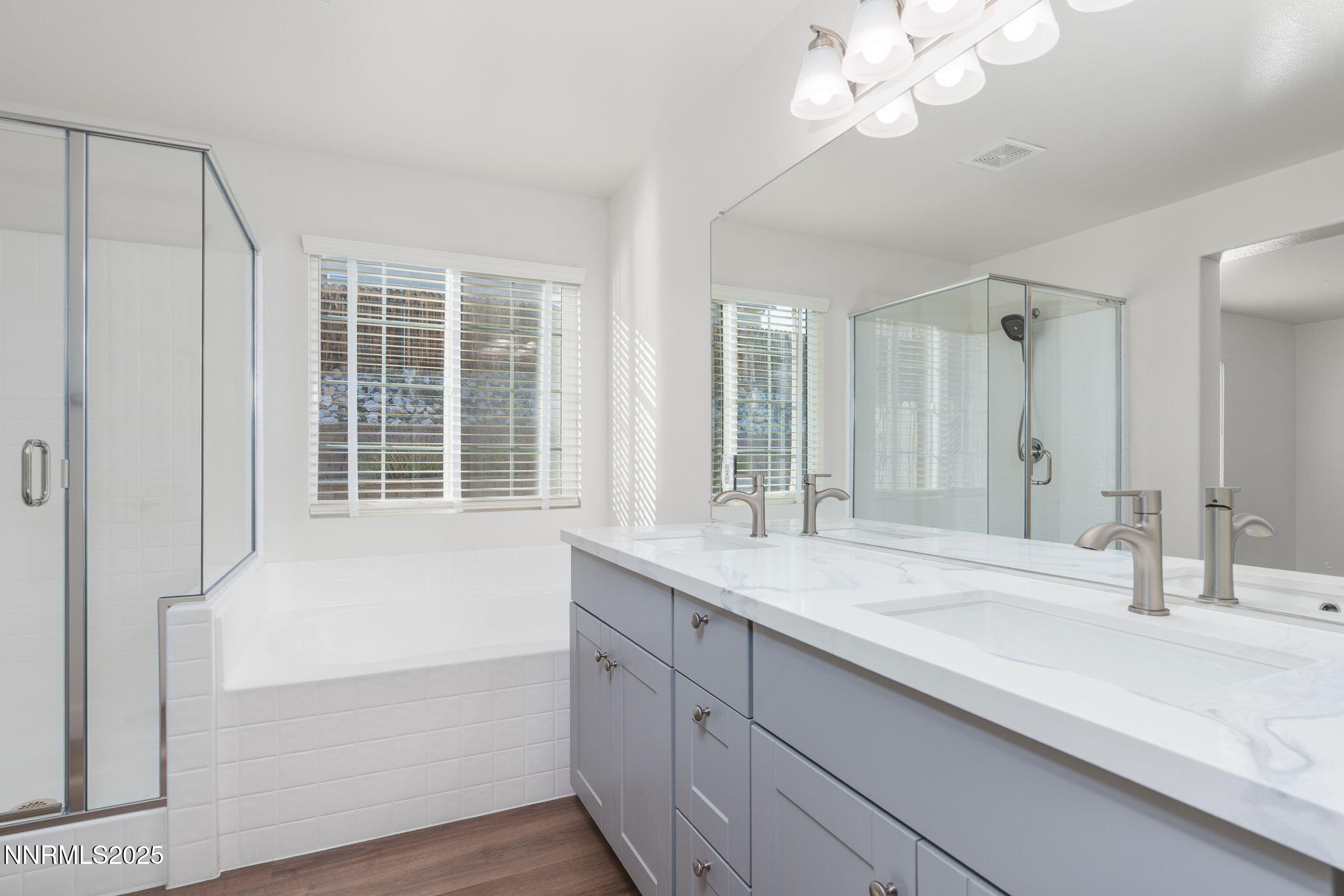 2905 Scepter Court Reno, NV 89503 - Photo 20 of 30 a bathroom with a granite countertop sink a large mirror and a bathtub with shower