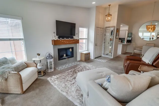 a living room with furniture a flat screen tv and a fireplace