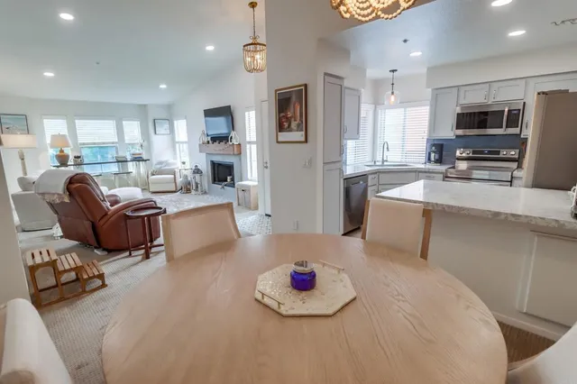 a kitchen with stainless steel appliances granite countertop a stove a sink a microwave a refrigerator and white cabinets