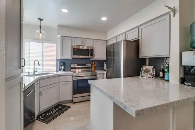 a kitchen with stainless steel appliances a stove sink microwave and cabinets