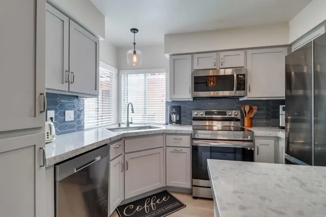 a kitchen with stainless steel appliances granite countertop a sink a stove and a microwave