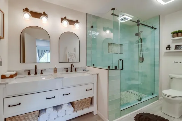 a bathroom with a shower a sink and toilet