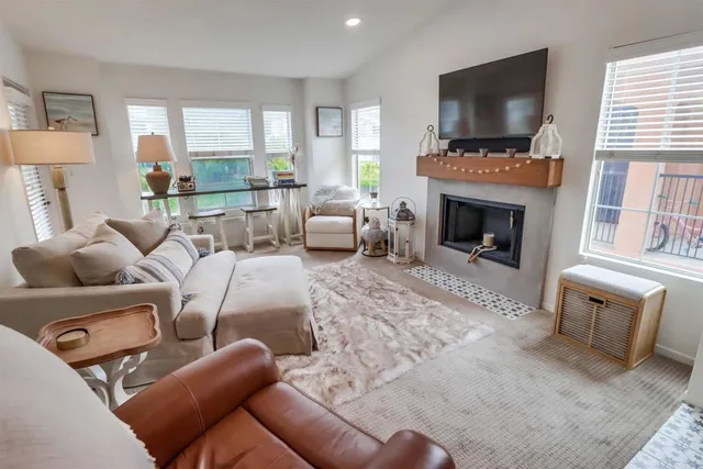 a living room with furniture a flat screen tv and a fireplace