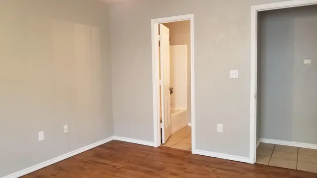 a view of an empty room with wooden floor