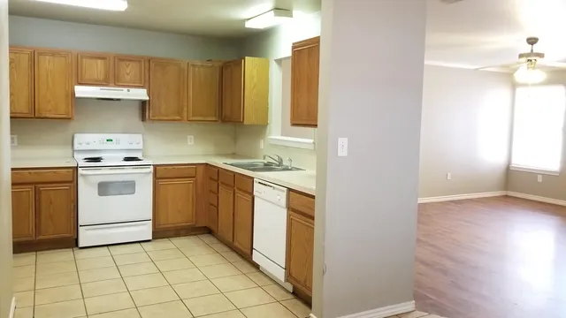 a kitchen with a stove sink and cabinets