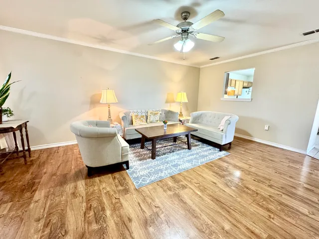 a living room with furniture and a wooden floor