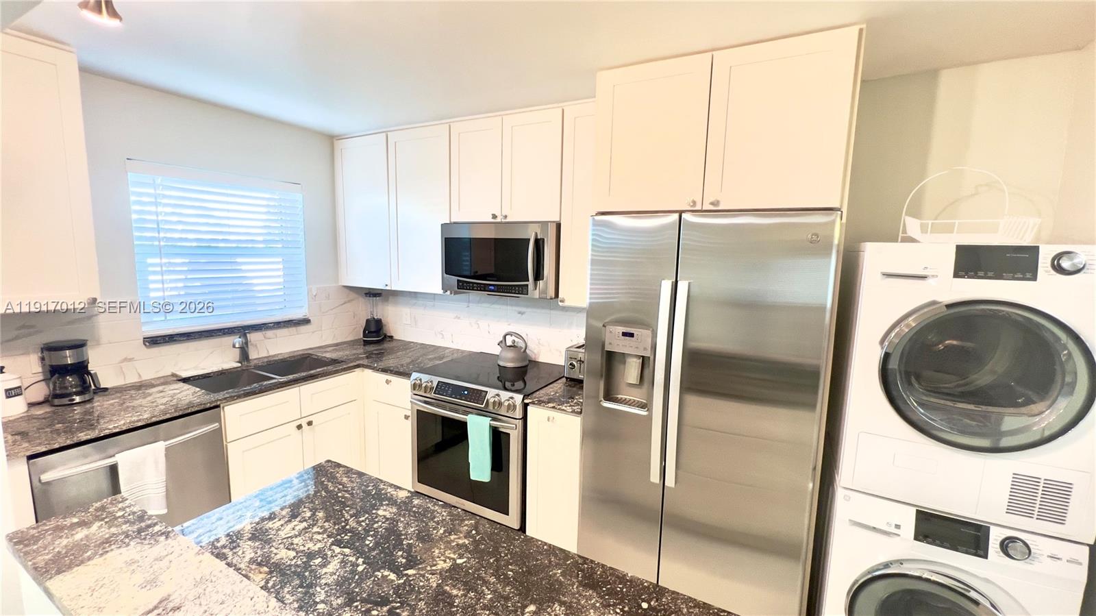 4380 27th Court Southwest, Unit 1104 Naples, FL 34116 - Photo 2 of 22 a kitchen with a sink a stove a microwave and refrigerator