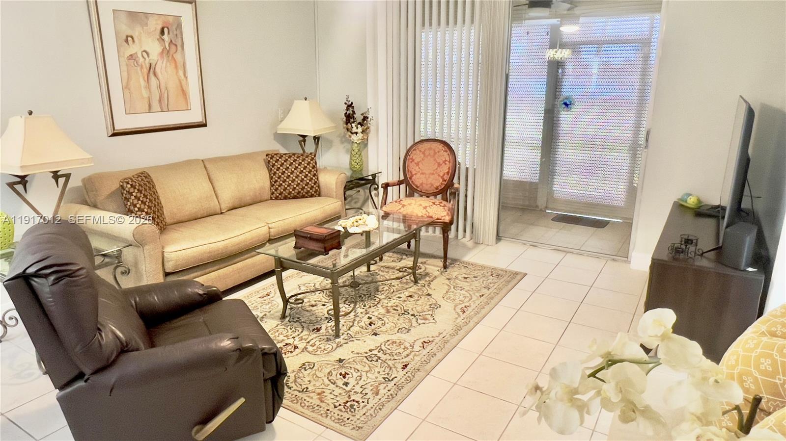 4380 27th Court Southwest, Unit 1104 Naples, FL 34116 - Photo 3 of 22 a living room with furniture and a mirror