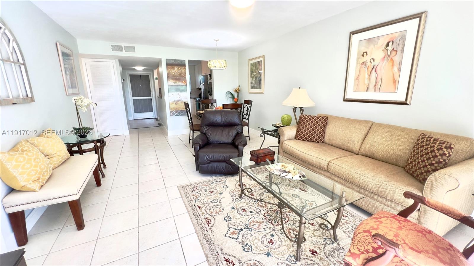 4380 27th Court Southwest, Unit 1104 Naples, FL 34116 - Photo 4 of 22 a living room with furniture a rug and a lamp