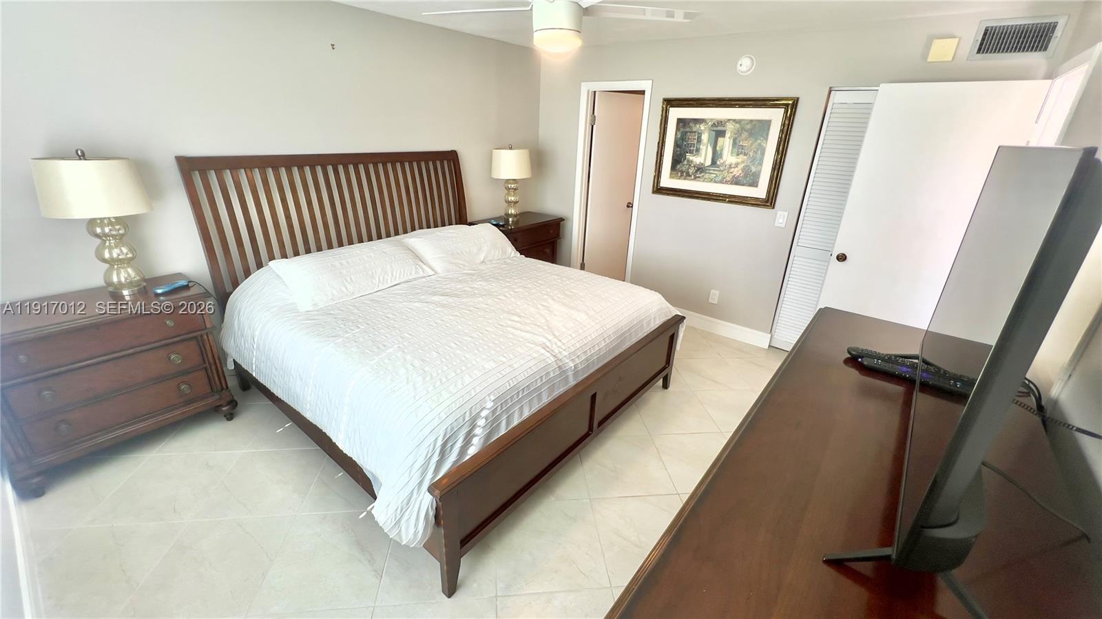 4380 27th Court Southwest, Unit 1104 Naples, FL 34116 - Photo 8 of 22 a bedroom with a bed and a night stand