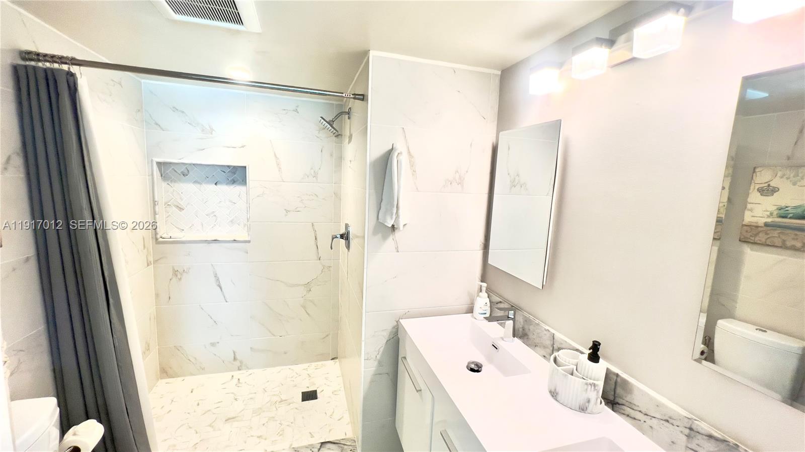 4380 27th Court Southwest, Unit 1104 Naples, FL 34116 - Photo 9 of 22 a bathroom with a sink and a mirror