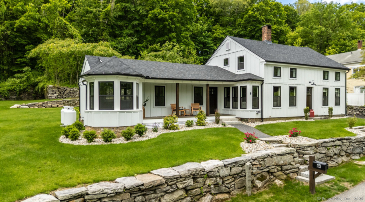 a front view of a house with a yard table and chairs