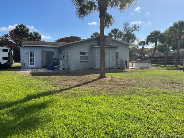 a view of a house with a yard and palm tree