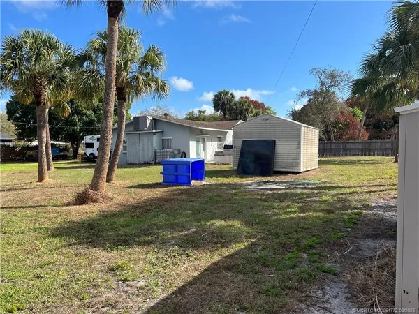 a view of a house with backyard and tree s