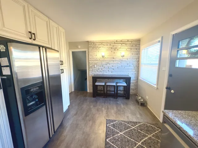 a kitchen with granite countertop a refrigerator and a stove top oven