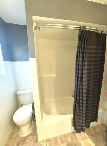a bathroom with a toilet and shower