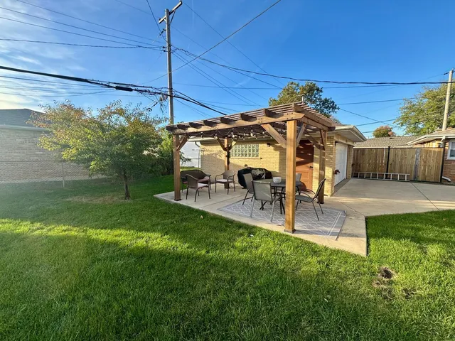 a view of a patio with a table and chairs under an umbrella
