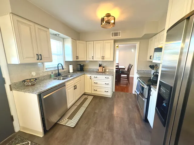 a kitchen with a sink appliances and cabinets