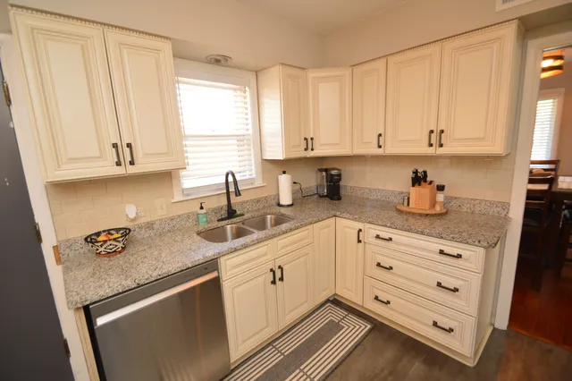 a kitchen with granite countertop white cabinets and white appliances