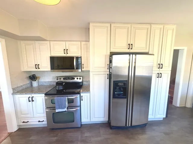 a kitchen with stainless steel appliances a refrigerator sink and microwave