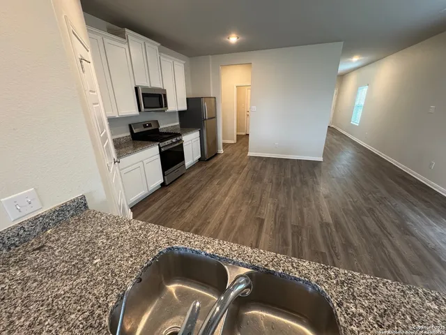 a kitchen with a sink a microwave and cabinets