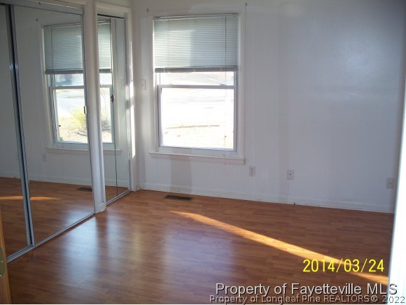 3636 Drayton Road Fayetteville, NC 28303 - Photo 12 of 25 an empty room with wooden floor and windows