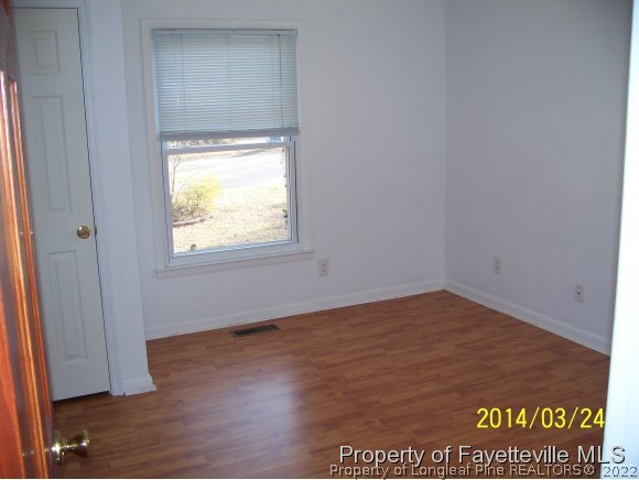 3636 Drayton Road Fayetteville, NC 28303 - Photo 13 of 25 a view of an empty room with wooden floor and a window