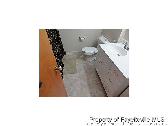 3636 Drayton Road Fayetteville, NC 28303 - Photo 23 of 25 a bathroom with a toilet sink and mirror