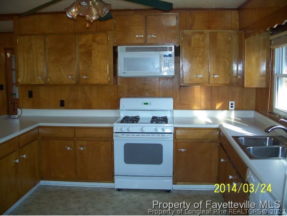3636 Drayton Road Fayetteville, NC 28303 - Photo 7 of 25 a kitchen with a sink stove and cabinets