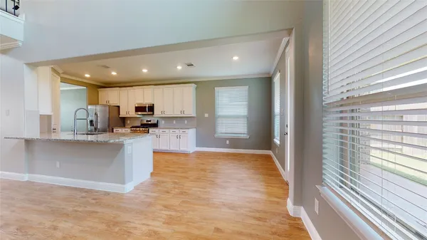 a view of kitchen with kitchen island wooden floor window and refrigerator