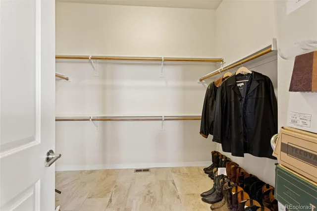 a view of walk in closet with clothes and shoes