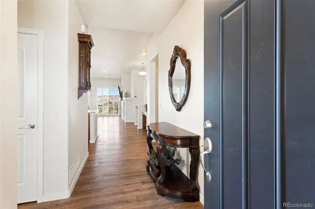 a view of a hallway with wooden floor and entryway