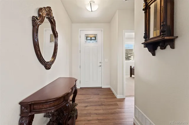 a view of a hallway with wooden floor and entryway