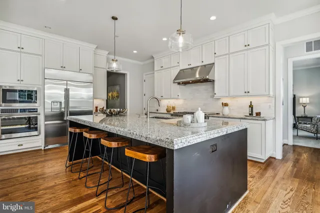a kitchen with stainless steel appliances granite countertop a stove a sink and a refrigerator