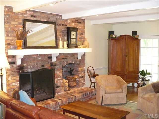 8633 Langtree Lane Raleigh, NC 27613 - Photo 2 of 12 a living room with furniture a window and a fireplace