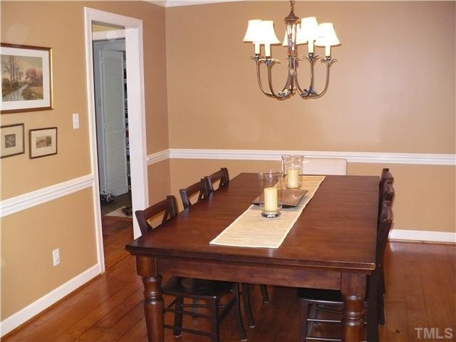 8633 Langtree Lane Raleigh, NC 27613 - Photo 4 of 12 a view of a dining room with furniture a chandelier and wooden floor