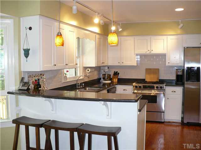 8633 Langtree Lane Raleigh, NC 27613 - Photo 5 of 12 a kitchen with a stove a sink and a refrigerator