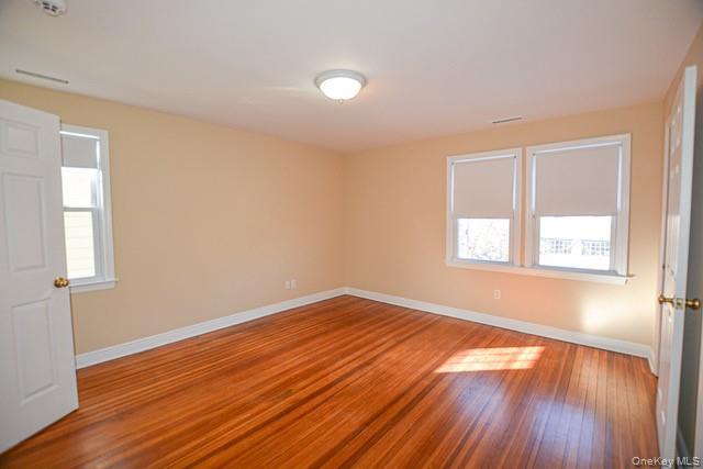 26 St Pauls Place New Rochelle, NY 10801 - Photo 13 of 16 an empty room with wooden floor and windows