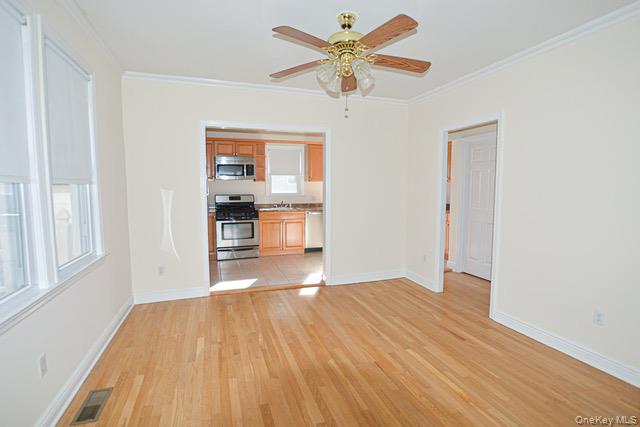 26 St Pauls Place New Rochelle, NY 10801 - Photo 4 of 16 a view of empty room with wooden floor and fan