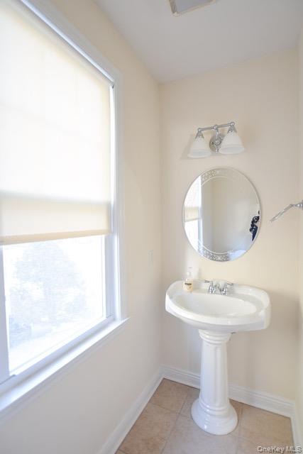 26 St Pauls Place New Rochelle, NY 10801 - Photo 6 of 16 a bathroom with a sink a mirror and a window