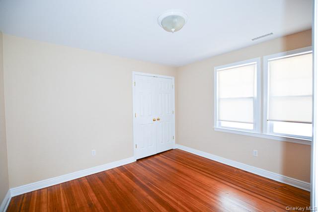 26 St Pauls Place New Rochelle, NY 10801 - Photo 10 of 16 an empty room with wooden floor and windows